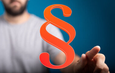 Stock photo of a person interacting with a 3D paragraph symbol, representing legal concepts, law,...