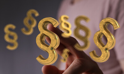 Abstract image of golden paragraph symbols floating, symbolizing law, legislation, and legal...