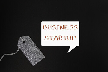 Business startup concept with speech bubble and glitter tag on dark background for branding