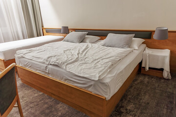 Modern hotel room with wooden furniture and comfortable beds in minimalist setting