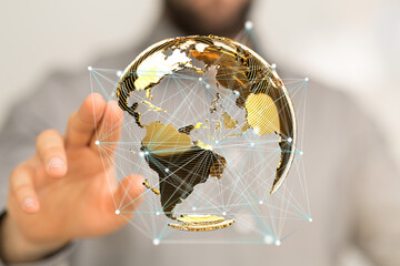 Hand interacting with a 3D golden globe, representing global network and connectivity.