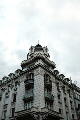 Obraz premium Classic corner building in Belgrade, Serbia. Features decorative balconies, sculpted elements, and a green dome roof. Example of elegant European architecture.