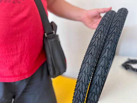 Bicycle mechanic holding new tires for repairing bikes