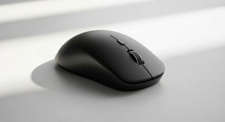 Sleek black wireless computer mouse casting a soft shadow on a textured surface