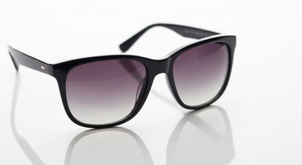 Chic oversized black sunglasses with gradient lenses on a reflective surface