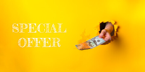 Hand holding cash emerging from a torn yellow background with promotional text for special offer
