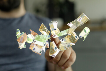 Close-up of a hand with euro banknotes floating around it.  Concept of finance, wealth, or success.