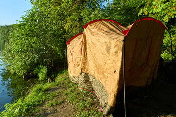 a man builds a tent in nature, camping theme