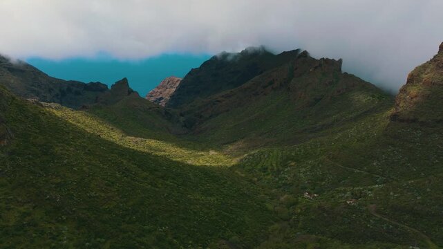 Aerial descent through misty Retamar valley revealing ocean horizon, Tenerife, Canary Islands