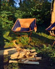 a tent with chairs and a burning campfire by the lake