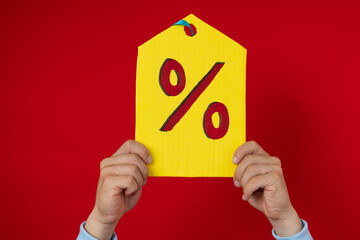 Male hands holding a large yellow tag with a percentage symbol, discount concept