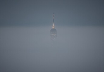 Skyscraper pierces thick fog