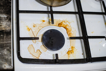 Close-up of a dirty gas stove with stains and grime, illustrating the need for cleaning and...