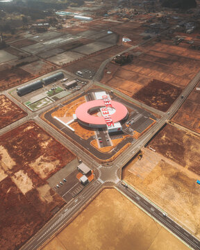 Aerial view of the circular building with the red roof amidst the brown fields and roads, Fukushima Daiichi Nuclear Power Plant, Fukushima, Japan.