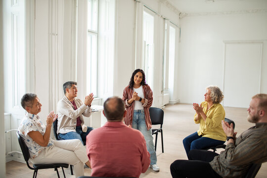 Close up of a group of people attending a group therapy session in a community center