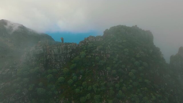 Aerial orbit of misty mountain near Masca revealing ocean through Retamar valley, Tenerife, Canary Islands