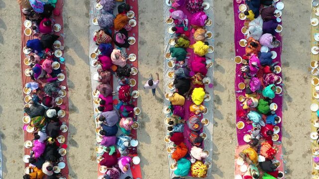 Bogura, Bangladesh - 25 July 2025: Aerial view of people seated at long tables, enjoying a meal together; a vibrant display of community and tradition.