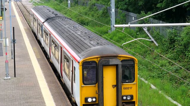 Short, two carriage passenger train leaving Treorchy station in South Wales, overhead view.