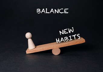 Wooden balance scale with a figurine representing new habits and personal growth concept