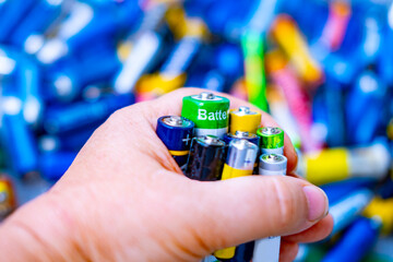 hand holding collection discarded batteries, Environmental consciousness, proper battery recycling...
