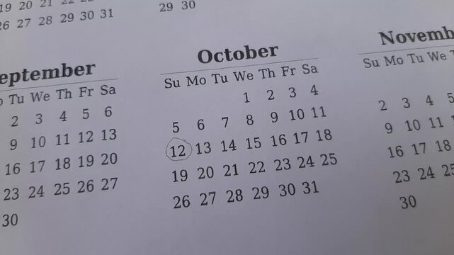 marking the October 12 date on the calendar	
