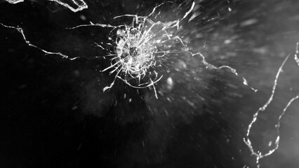 Close-up of gunshot through the glass, shattering against the black background