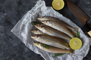 Raw Sillago fish on baking paper with lime and rosemary