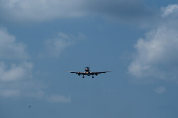 The airplane approaches the airport against a backdrop of clouds. The airplane is ready to land....
