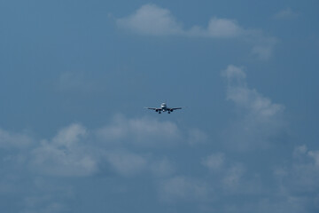 The airplane approaches the airport against a backdrop of clouds. The airplane is ready to land....