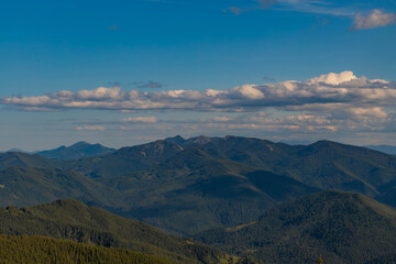 endless green mountains and white clouds in the blue sky