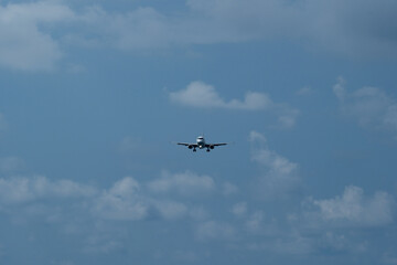 The airplane approaches the airport against a backdrop of clouds. The airplane is ready to land....