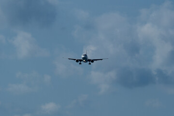 The airplane approaches the airport against a backdrop of clouds. The airplane is ready to land....