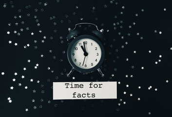 Vintage alarm clock surrounded by scattered silver stars on a dark background with text