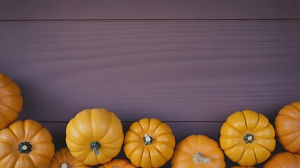 A row of small orange pumpkins lined up on a dark wooden surface with copy space above