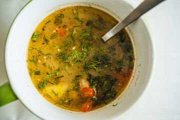 A steaming bowl of hearty soup filled with colorful vegetables and garnished with fresh herbs sits on a kitchen table Perfect for a comforting meal during cold days