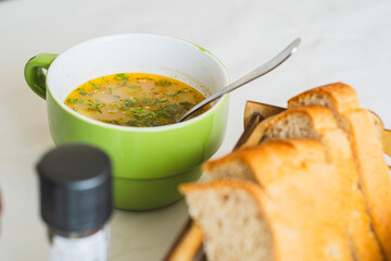 A steaming bowl of hearty soup filled with colorful vegetables and garnished with fresh herbs sits on a kitchen table Perfect for a comforting meal during cold days
