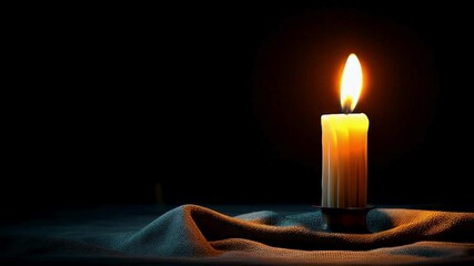A single candle emits a warm, flickering light, its flame casting shadows in a dimly lit room, evoking a sense of tranquility and contemplation. The candle rests on a soft cloth. - Powered by Adobe