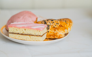 A tempting assortment of baked goods features a colorful array of pastries topped with creamy icing...