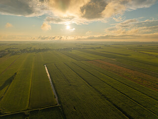 Aerial view of Dutch farmland near Amersfoort at sunset with dramatic sky and green fields
