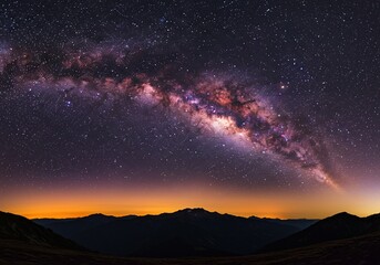 The milky way galaxy stretches across the starry night sky above mountains