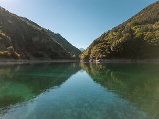 Obraz premium Aerial drone view of Lake San Domenico: emerald green in color. With its double arch, it is an artificial lake in the municipality of Villalago in the province of L'Aquila, near the hermitage 