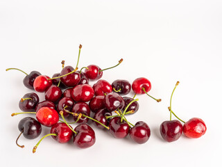 Fresh red and dark cherries with stems, isolated on white background.
