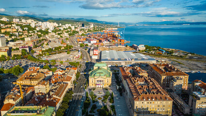 Fototapeta premium Rijeka city center and waterfront aerial view at sunset, panoramic view of the Kvarner Gulf in Croatia. Scenic harbor with boats, historic architecture, container terminal, canals, seafront promenade