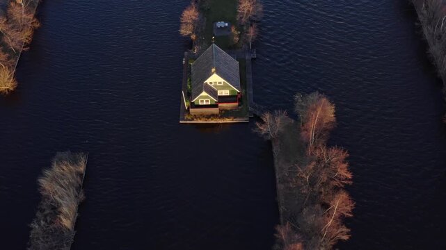 Aerial view of houses nestled on small islands surrounded by water, creating an idyllic landscape with a stark contrast, Breukelen, Utrecht, Netherlands.
