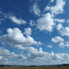 Obraz premium flat landscape and a a clear summer sky viewed straight ahead, deep blue with scattered white fluffy cumulus clouds