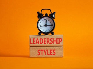 Leadership Styles symbol. Concept word Leadership Styles on wooden blocks. Beautiful orange background with alarm clock. Business and Leadership Styles concept. Copy space
