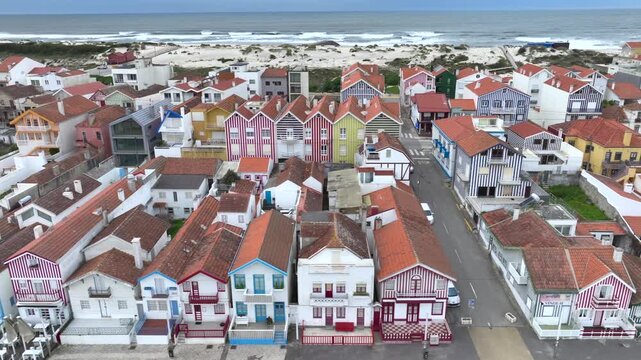 Aerial drone sideways panning of colourful houses along Costa Nova do Prado beach, Portugal