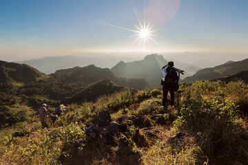 A photographer or traveller with a professional DSLR camera on a tripod in the nature for...