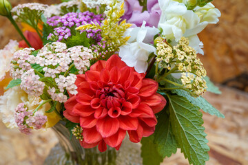 Summer bouqet of bright flowers. Focus on a bright orange dahlia.