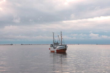 Fototapeta premium A small ship enters the harbor bay